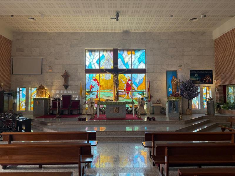 Presbiterio de la parroquia, con el crucifijo y la gran vidriera