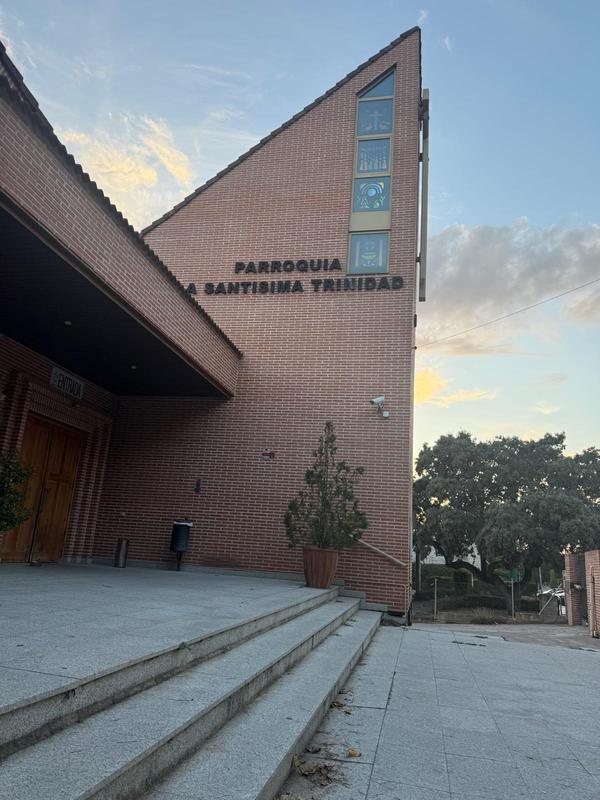Fachada lateral con el rótulo de la parroquia y las vidrieras de la torre
